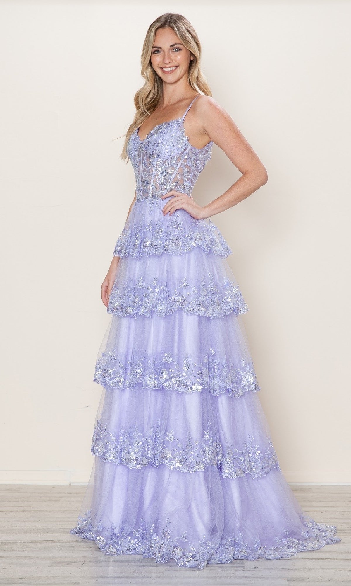 A woman smiles indoors in the Long Glitter-Lace Tiered Prom Dress (Poly USA 9548), a light purple tulle gown with floral details and spaghetti straps—capturing elegant Southern style.